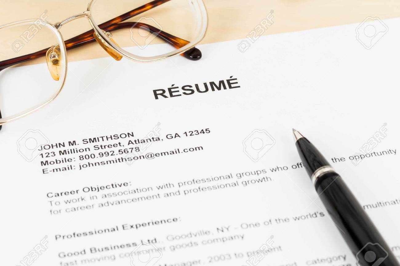 Resume with pen and glasses on table closeup